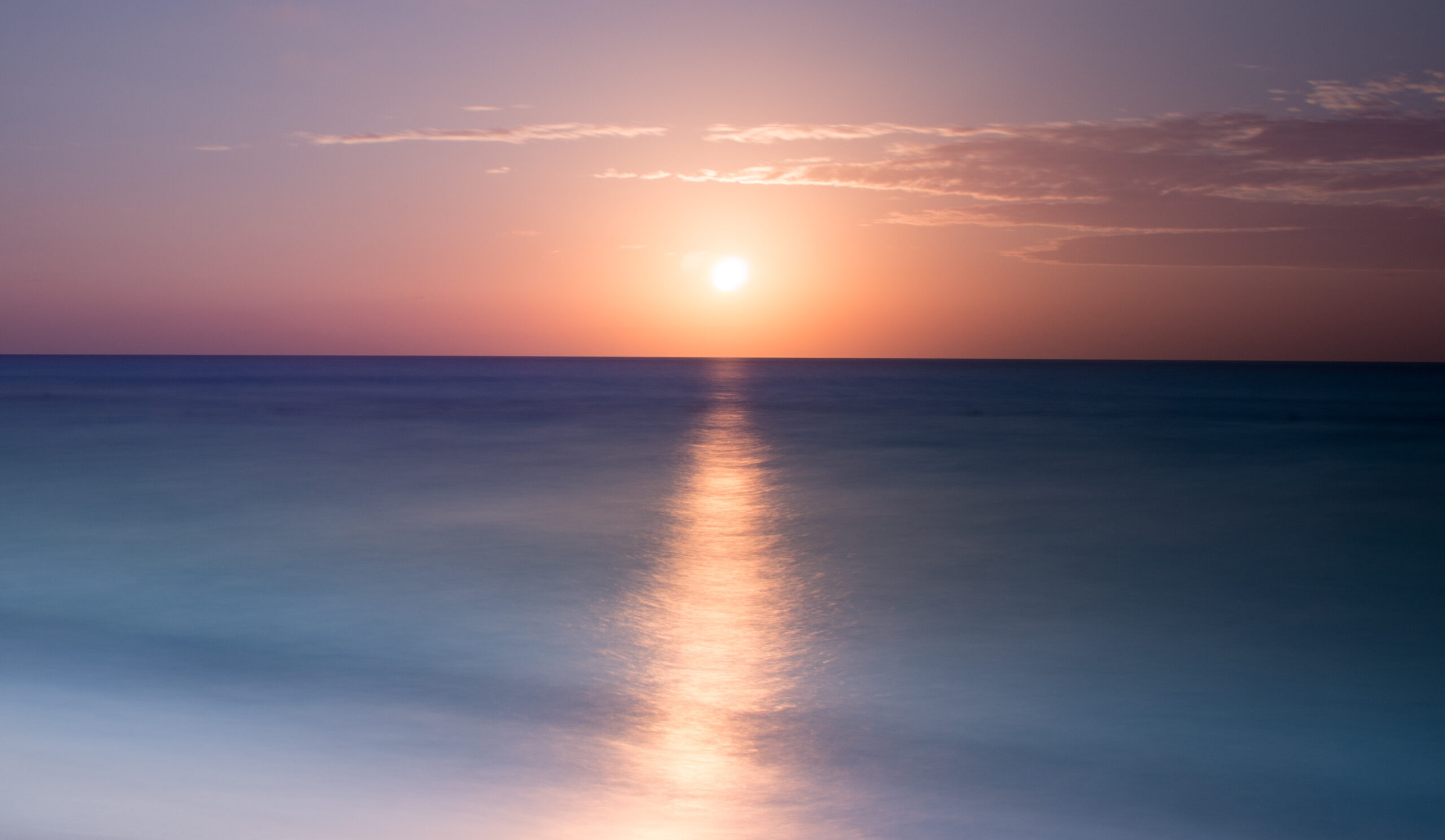 Tranquil beach at sunrise with gentle ocean waves